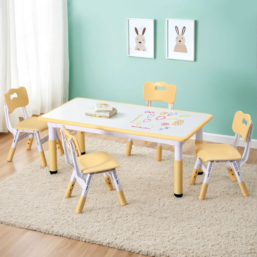 Children's table and chairs set with a whiteboard top in a room with light blue walls and rabbit-themed decor.