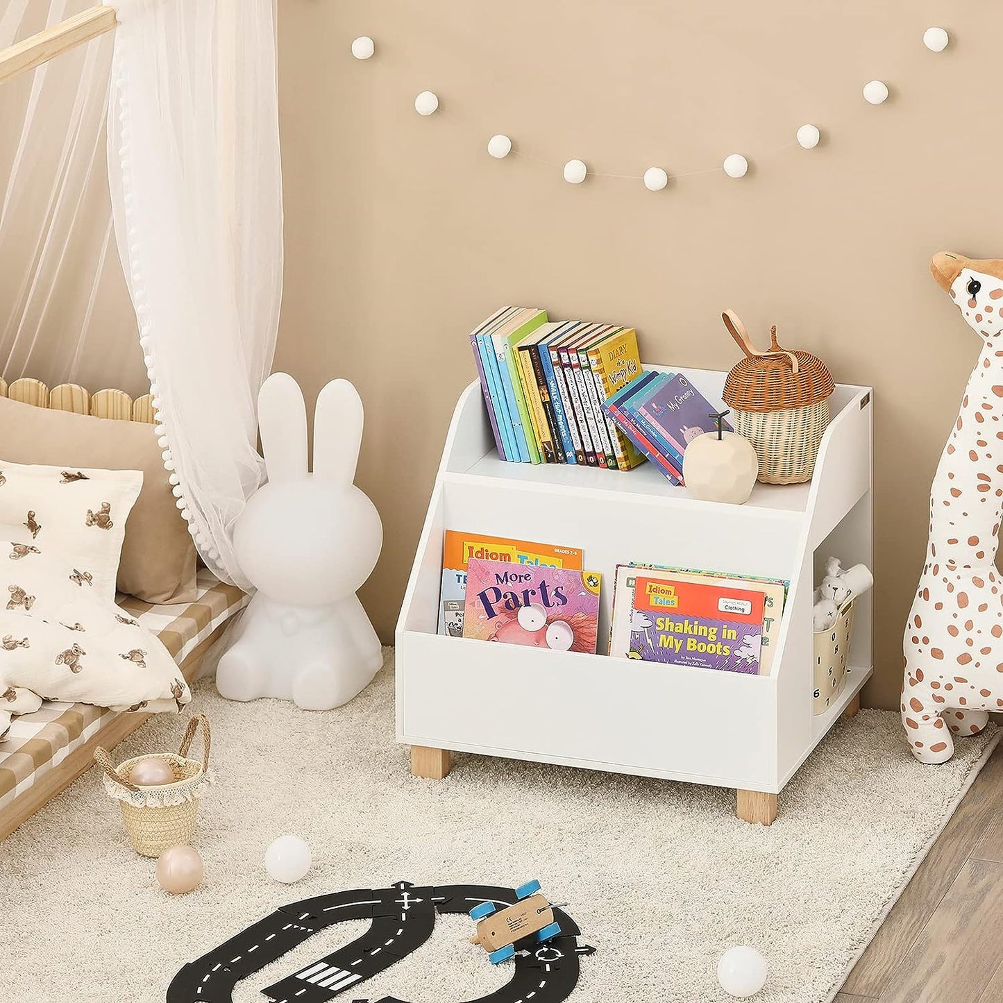 Children's room with a white bookshelf filled with books, toys, and decorative items.