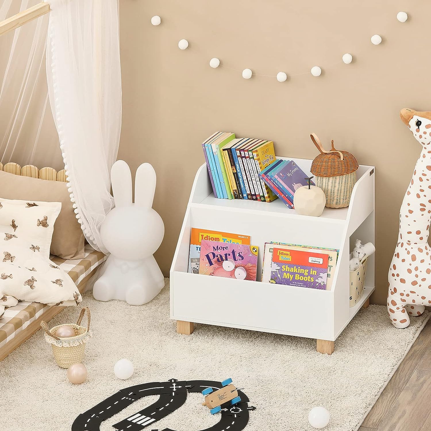 Children's room with a white bookshelf filled with books, toys, and decorative items.