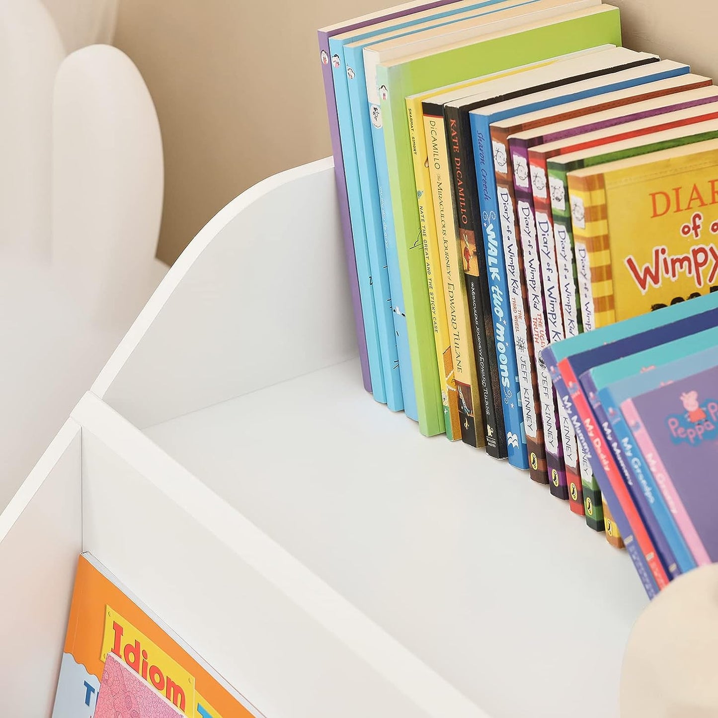 Children's books stacked on a white bookshelf