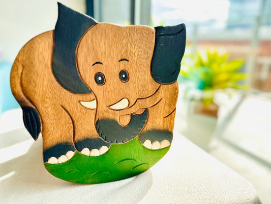 Wooden toy elephant on a white surface with a blurred background